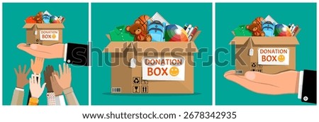 Man hands holding donation box with clothes, toys, books, and school supplies for charity. Volunteering and social assistance concept.