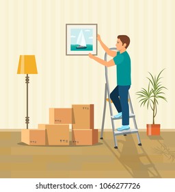 Man Hanging Picture On The Wall. Moving Boxes In New House. Vector Flat Style Illustration