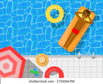 A man having tan skin laying on a floating bed in a swimming pool, umbrella and hat at a side