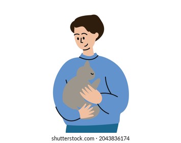 A man is holding a cat. A pet on your hands. A man with a kitten in his arms.