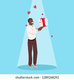 man holding gift box wrapped surprise happy valentines day holiday celebration concept african guy standing over heart shapes background male full length character flat