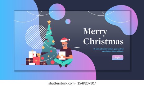 man holding gift present box merry christmas happy new year holiday celebration concept guy wearing santa hat sitting near fir tree flat full length copy space horizontal vector illustration