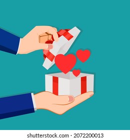 Man holding in hands open gift box with red heart. Gift of love concept
