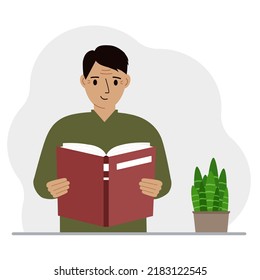 El hombre tiene un libro grande en sus manos.
