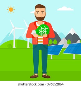 Man holding lightbulb with windmills inside.