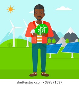 Man holding lightbulb with windmills inside.
