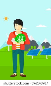 Man holding lightbulb with windmills inside.