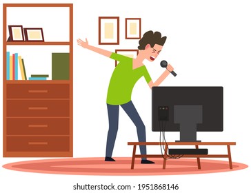 Man holding microphone and singing in karaoke to music. Boy stands with mike next to TV at home