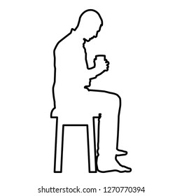 Man holding mug and looking at the contents inside while sitting on stool Concept of calm and home comfort icon black color