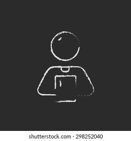 Hombre sujetando una tableta de pantalla táctil con la mano dibujada en tiza sobre un icono blanco vector de pizarra en un fondo negro