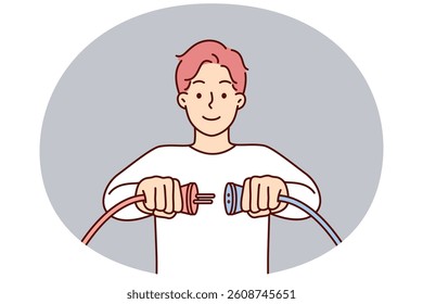 Man holding two cords with high voltage wish to connect wires to start electrical equipment or electric car. Concept increasing electrical current consumption for daily or work tasks