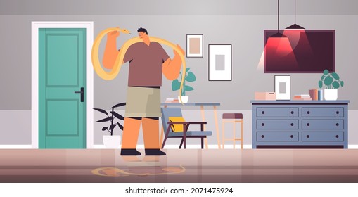 man holding yellow python snake guy having dangerous reptile pet living room interior horizontal