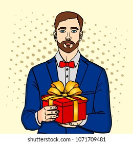 Man holds big gift box. Vector illustration in retro comic pop art style. A guy with christmas or birthday gift.