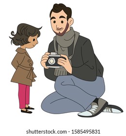 A man holds a camera with a little girl next to it. A father having fun with his daughter. A father takes pictures with his daughter. Photographer