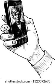 Man holds in his hand a mobile phone with a photo on the screen