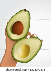 A man holds in his hand two halves of a ripe avocado