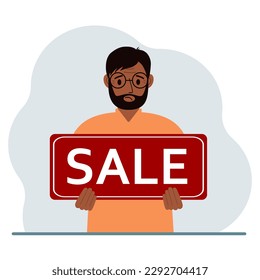 Ein Mann hält ein großes Zeichen mit dem Text SALE in den Händen.