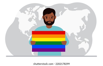 A man holds an lgbt flag in his hands against the backdrop of a world map.