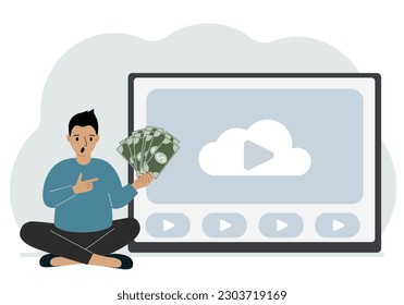 A man holds paper banknotes in his hand, next to a computer with a video. Freelancer, earning money, working on the Internet, training, coaching, business, remote work.