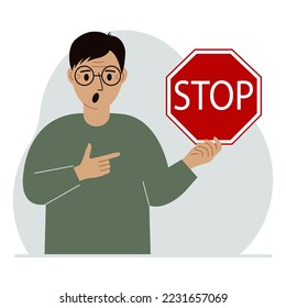 A man holds a red stop sign in his hand.