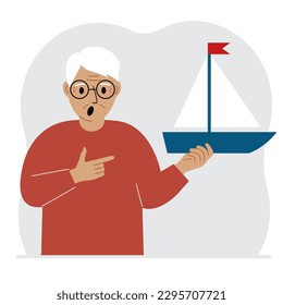 A man holds a sailing yacht in his hand. Concepts of freedom, hope and big plans. Hobby, sport or business.