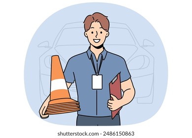 Man instructor from driving school smiles and holds traffic cones inviting to take exam for driver license. Guy employee of car school advertises services company teaching driving.