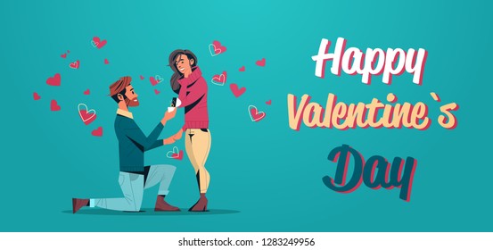 man kneeling holding engagement ring proposing to woman marry him happy valentines day concept young couple in love marriage offer greeting card horizontal