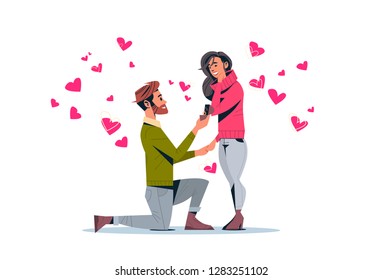 man kneeling holding engagement ring proposing woman marry him happy valentines day concept couple in love wedding marriage offer over pink heart shapes horizontal isolated