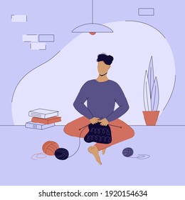Man knits sitting at home in the lotus position. Man knitting or men's hobbies concept.