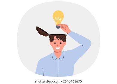 Man learns about innovative idea puts light bulb inside head to improve own creative thinking. Brilliant idea from business guy came up with new invention during brainstorming session