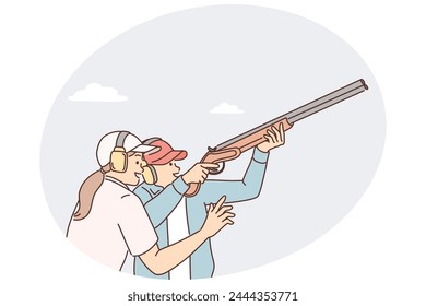 Der Mann lernt, wie man unter Aufsicht eines Frauentrainers Gewehr hält und Becken mit Schusswaffen schießt. Professioneller Sportler in Schutzkopfhörern ist im Gewehrschießen vor wichtigen Wettkämpfen beschäftigt
