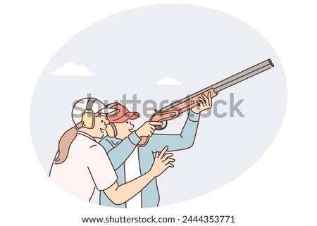 Man learns how to hold rifle and shoot cymbals with firearms under supervision woman trainer. Professional athlete in protective headphones is engaged in rifle shooting before important competitions