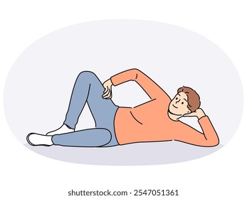 Man lies on floor with hand under head and with smile looks at screen, offering to relax and unwind. Happy guy lies on ground and smiles, feeling lazy orlacking initiative for personal growth.