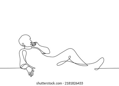 man lies relaxed watching something - one line drawing vector. concept horizontal full length male portrait