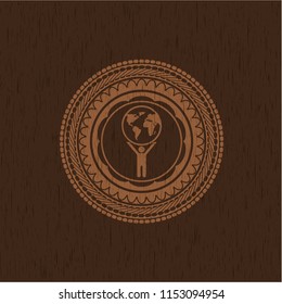 man lifting world icon inside retro style wood emblem