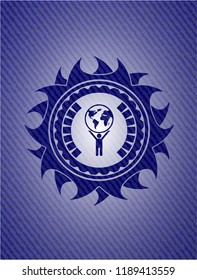 man lifting world icon inside jean or denim emblem or badge background