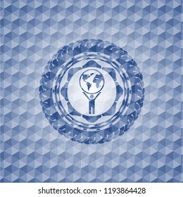 man lifting world icon inside blue polygonal emblem.