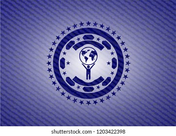 man lifting world icon inside badge with denim texture