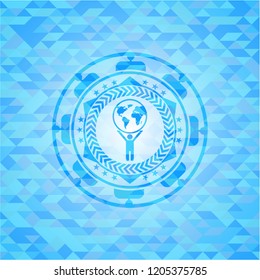 man lifting world icon inside realistic light blue emblem. Mosaic background