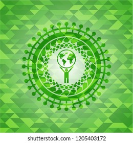 man lifting world icon inside green emblem with triangle mosaic background