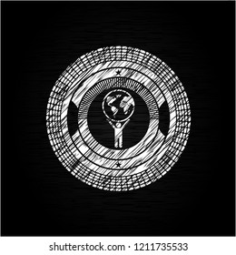 man lifting world icon inside chalkboard emblem