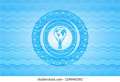 man lifting world icon inside water representation badge.