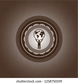 man lifting world icon inside wood emblem. Vintage.