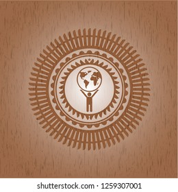 man lifting world icon inside wood emblem