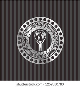 man lifting world icon inside silvery emblem
