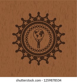 man lifting world icon inside wood emblem