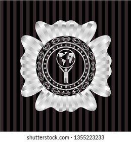man lifting world icon inside silver emblem