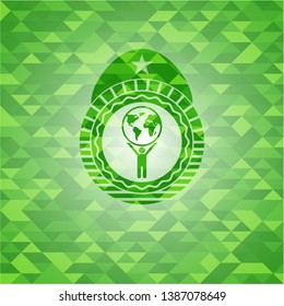 man lifting world icon inside green emblem. Mosaic background