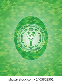 man lifting world icon inside green emblem. Mosaic background