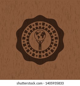 man lifting world icon inside realistic wood emblem